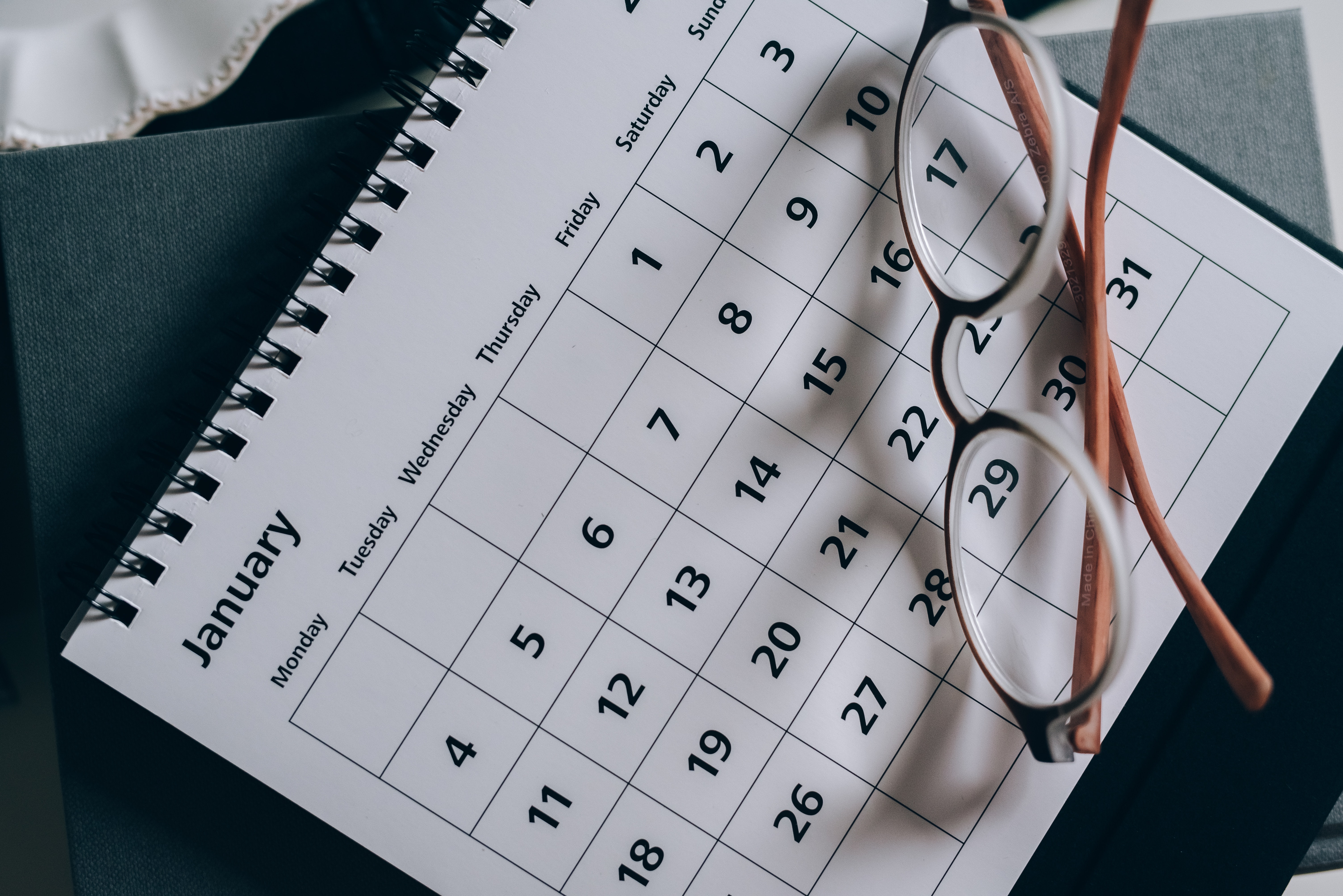 photo of a calendar in the month of January and a pair of glasses. 